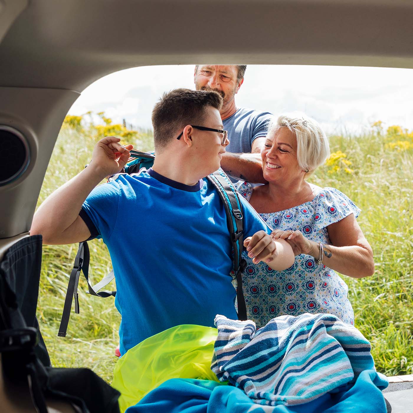 boy with autism putting on a backpack to go for a hike