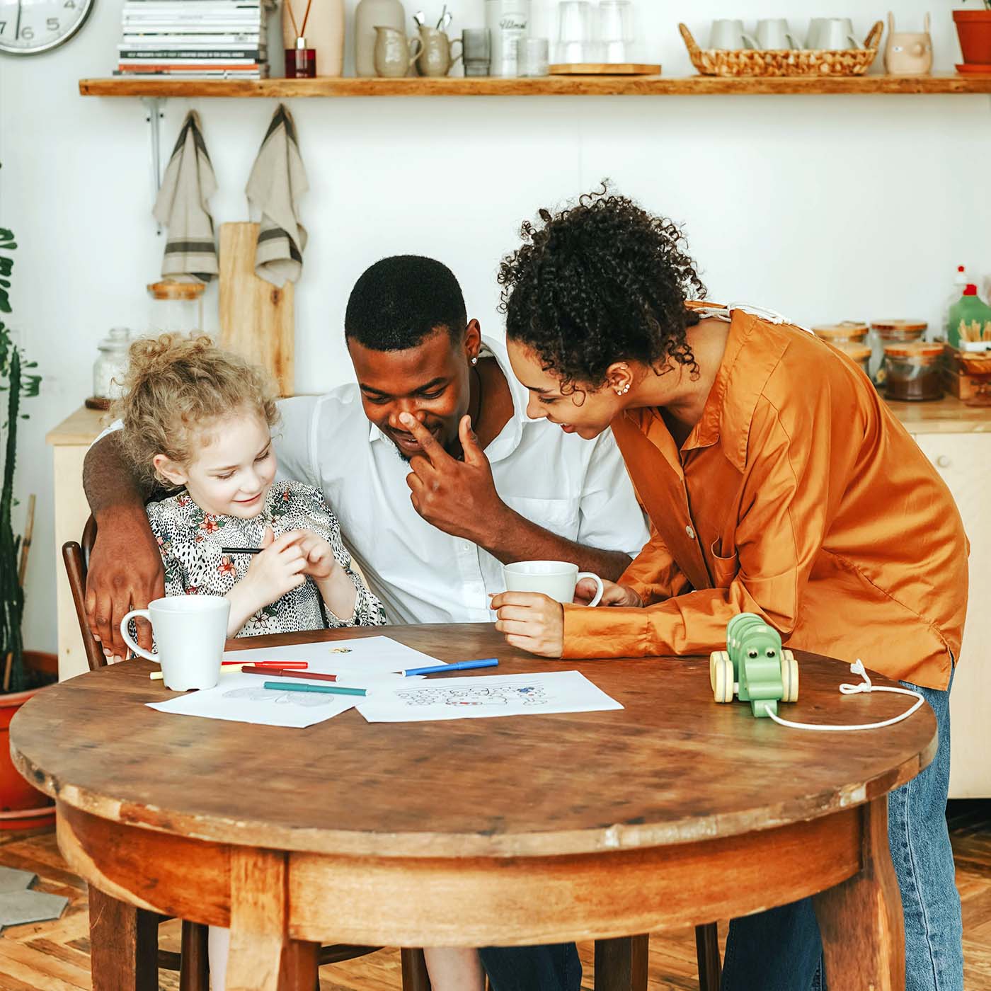 foster parents looking at foster childs drawing at their kitchen table