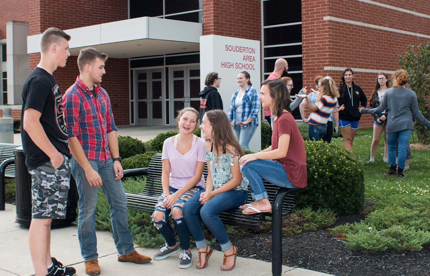 high school teens hanging out and talking with friends outside their high school