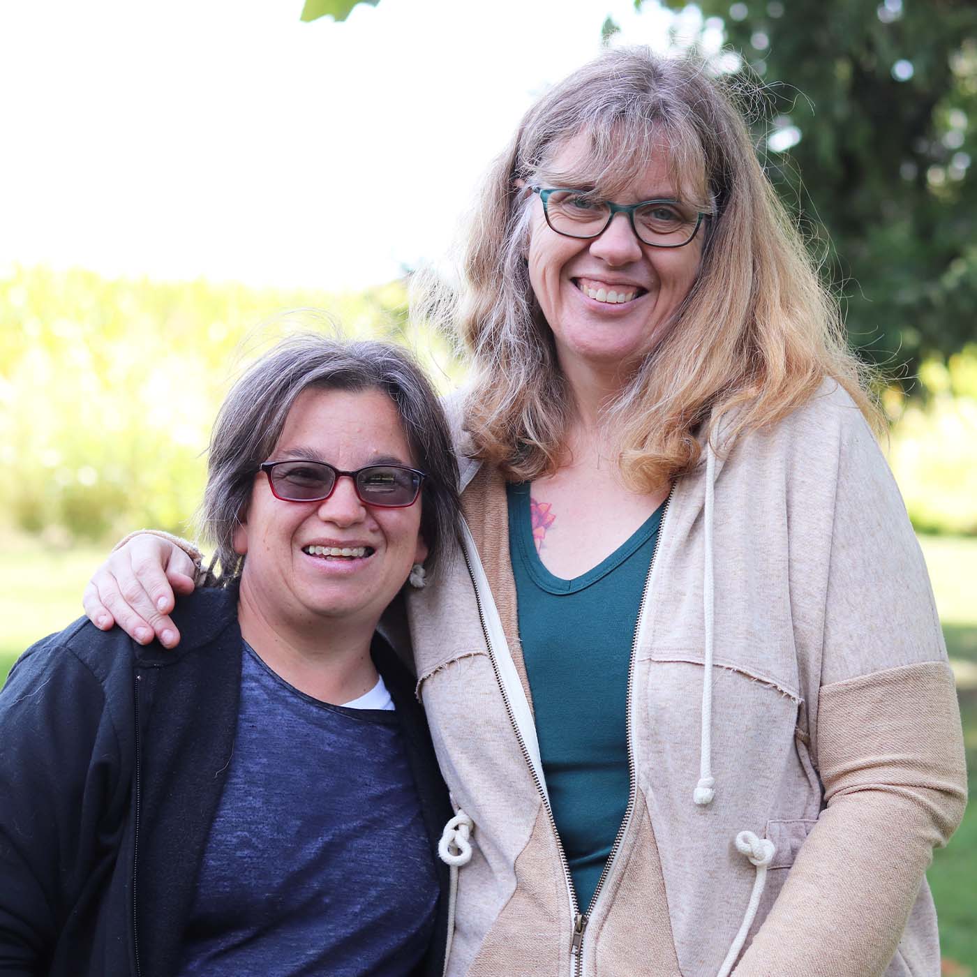 two women sharing life smiling together outside