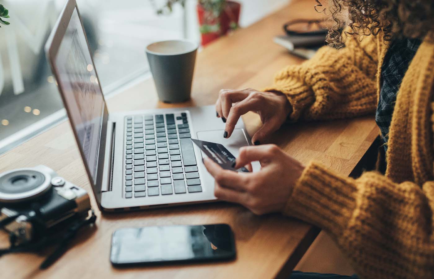 a lady shopping online on her laptop with card in hand ready to checkout