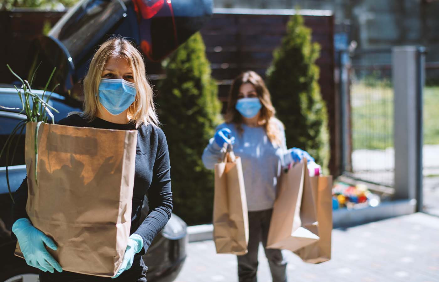 ladies carrying bags of donated goods