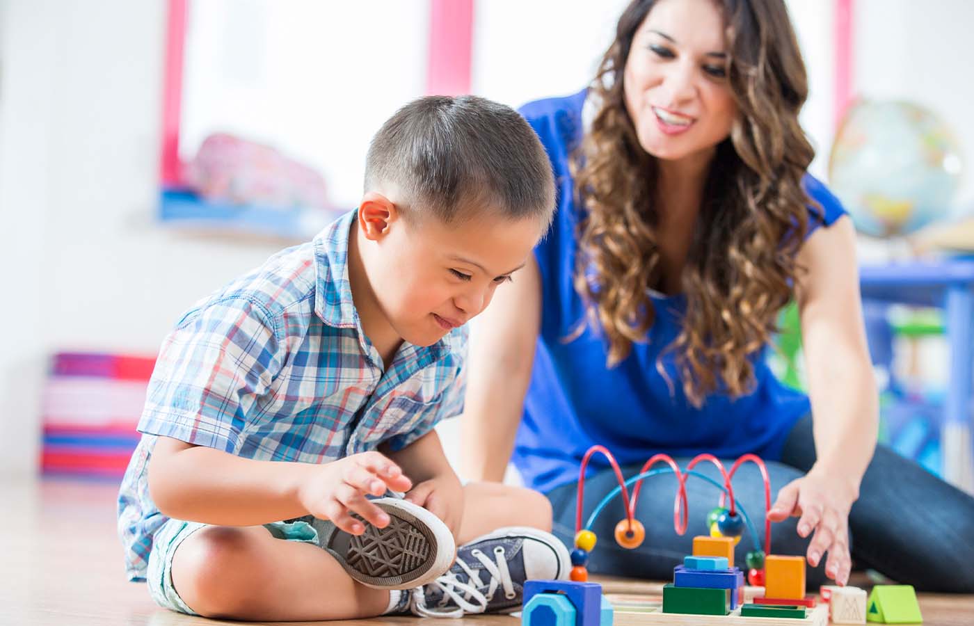 lady playing toys with a young boy with an intellectual disability