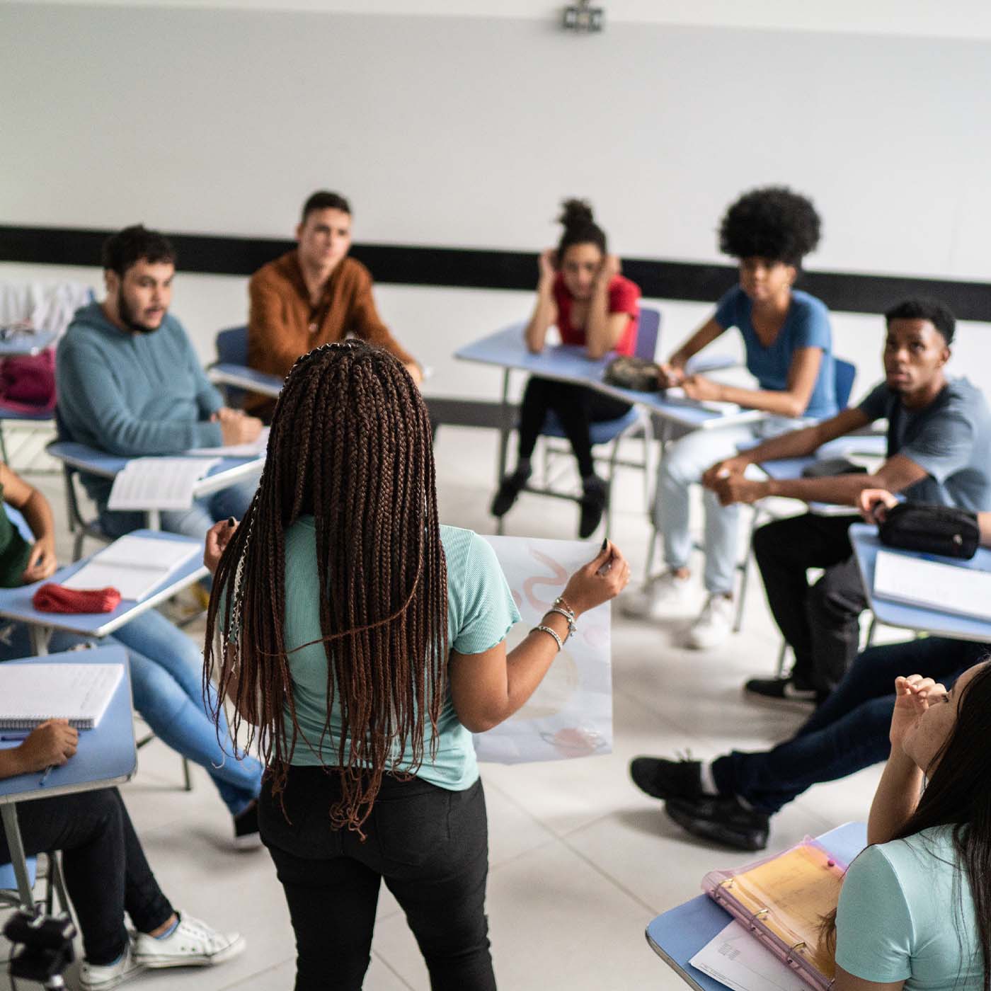 teenager practicing a presentation with a group of other teens