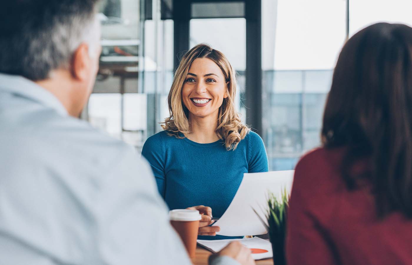 young lady meeting with her employers with paperwork in hand