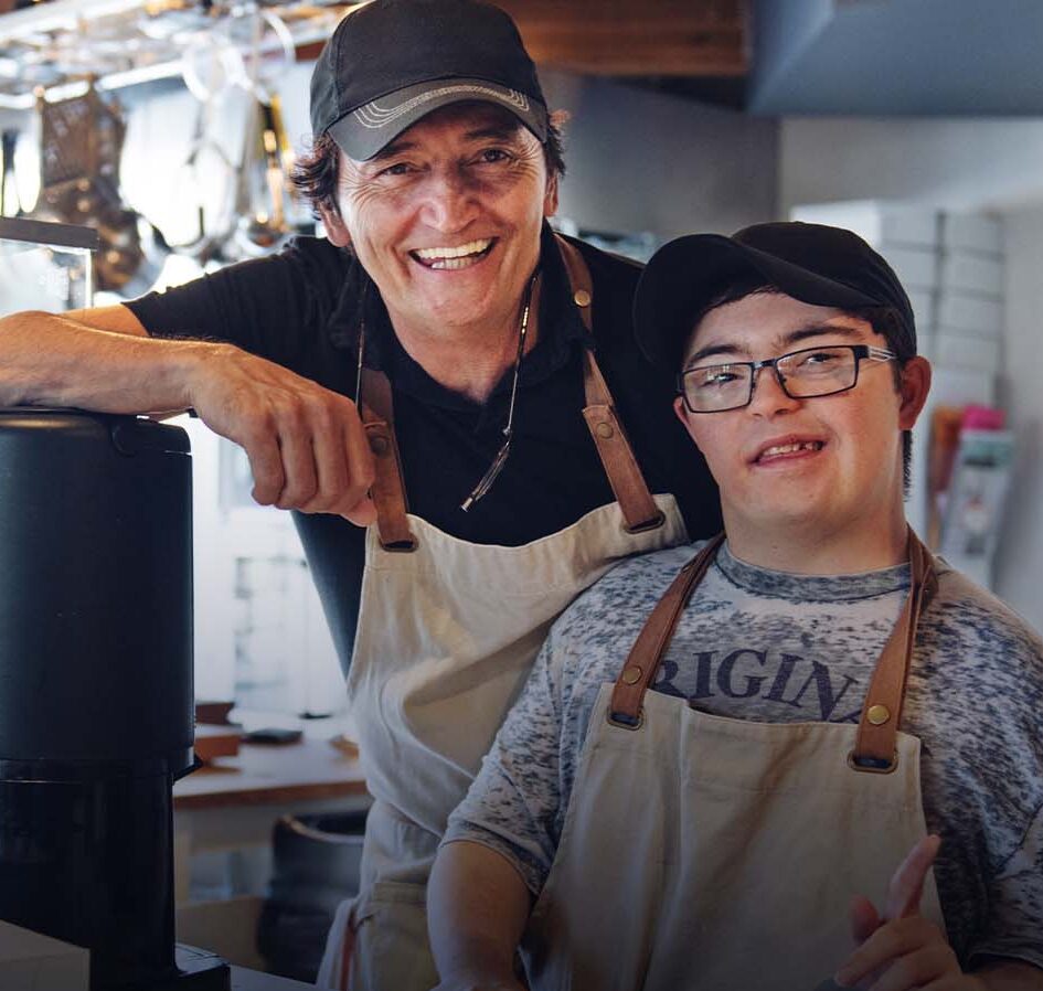 boss and employee with disability smiling at a coffee shop